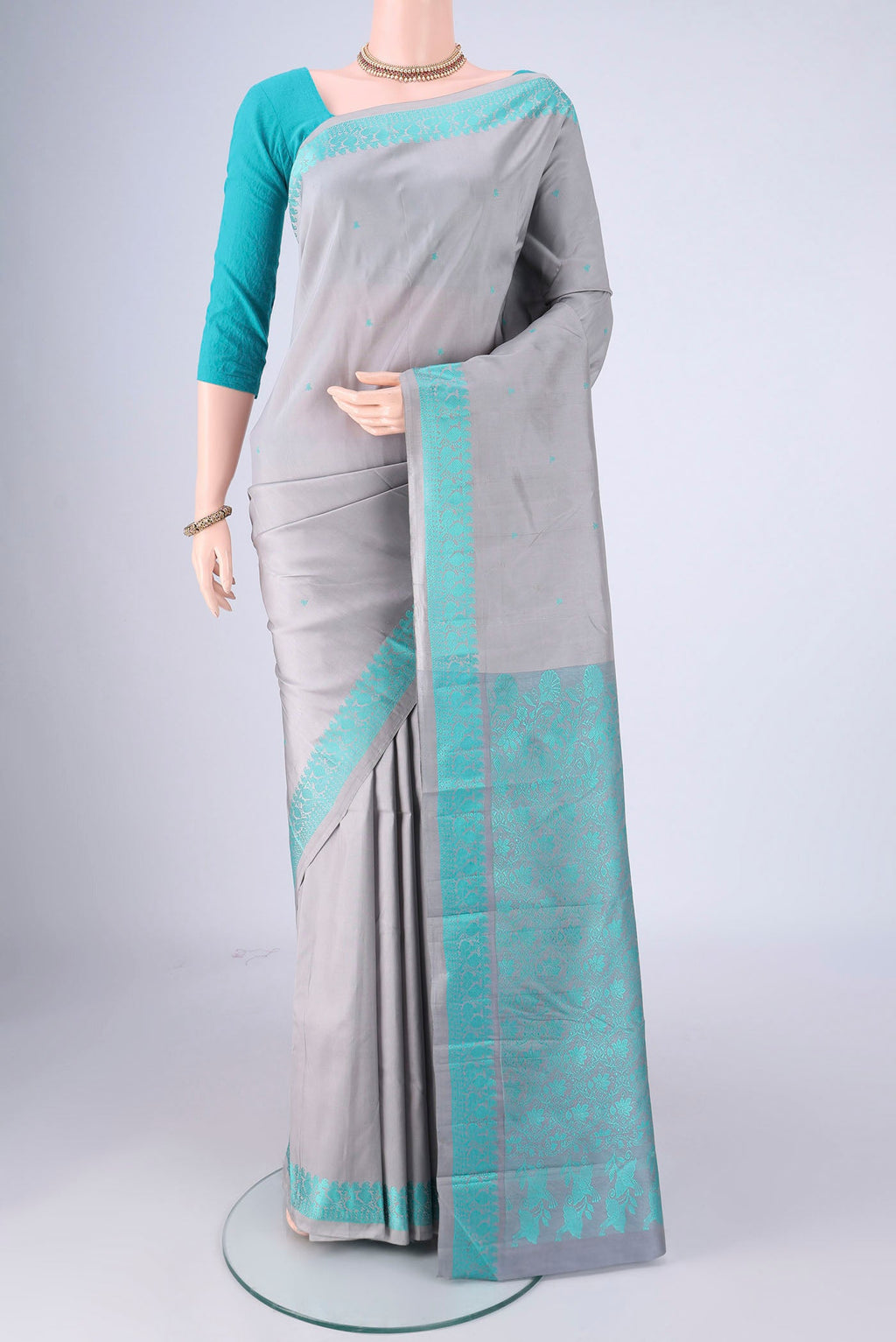 Grey Kanchipuram Silk Saree with Thread Butta on the body and Thread Border.  displayed on a mannequin