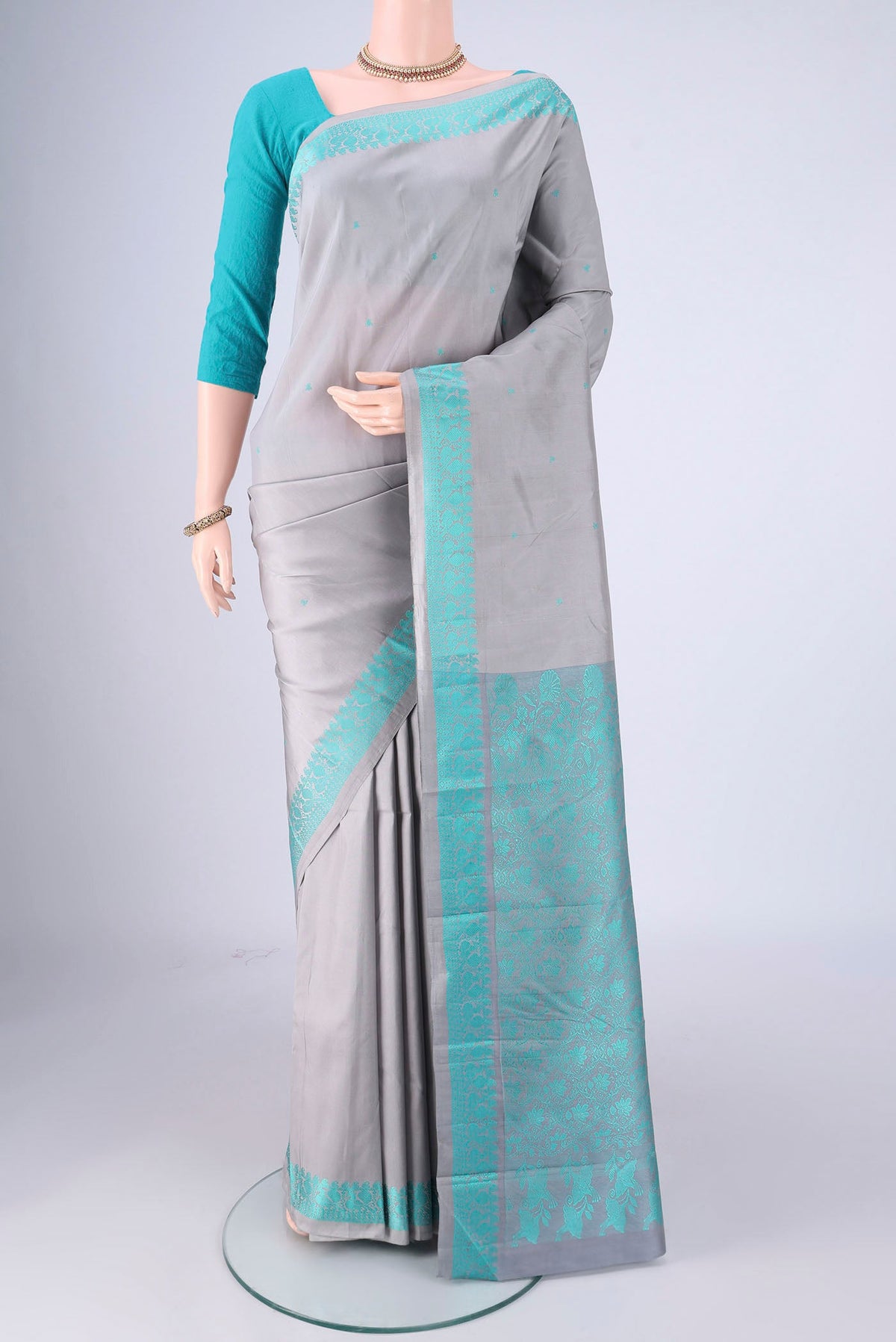 Grey Kanchipuram Silk Saree with Thread Butta on the body and Thread Border.  displayed on a mannequin