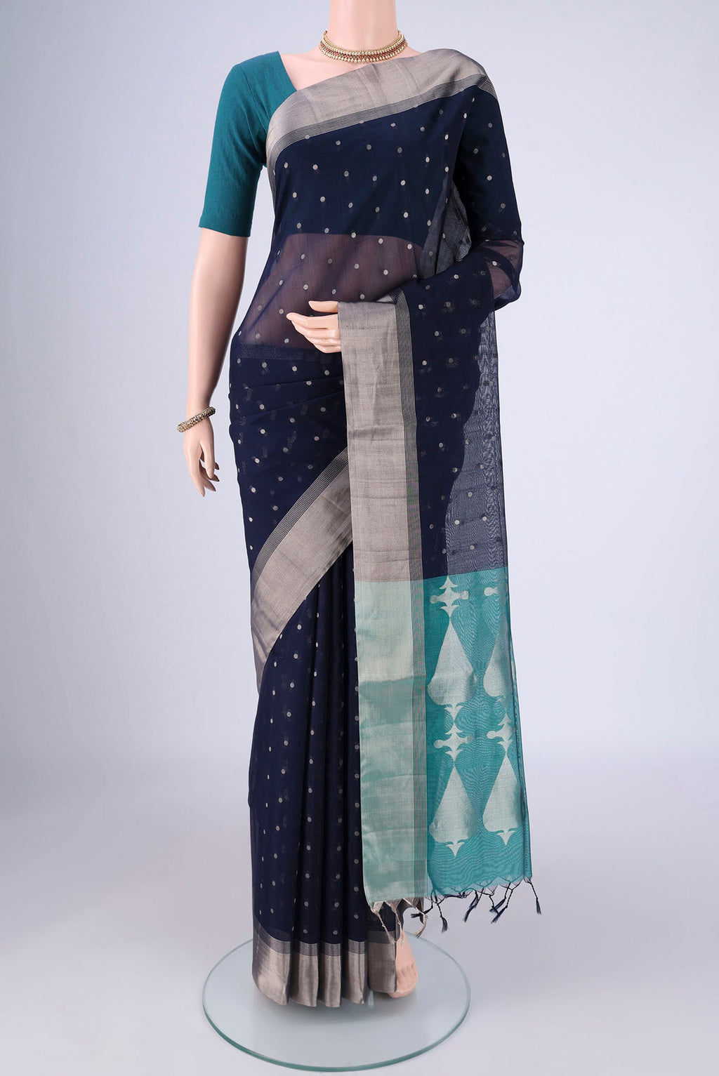 Navy Blue Silk Cotton Saree with Zari Butta on the body and Zari Border.  displayed on a mannequin
