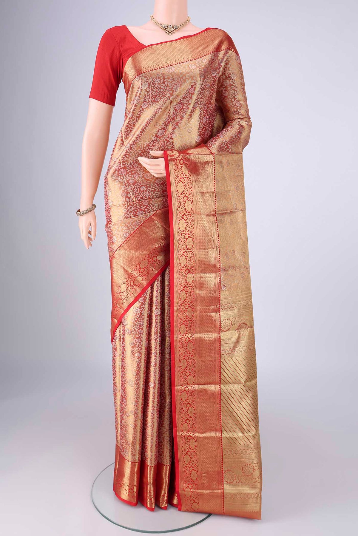 Gold with Red Dual Tone Kanjivaram Tissue Silk Saree with Zari Brocade on the body and Zari Border.  displayed on a mannequin
