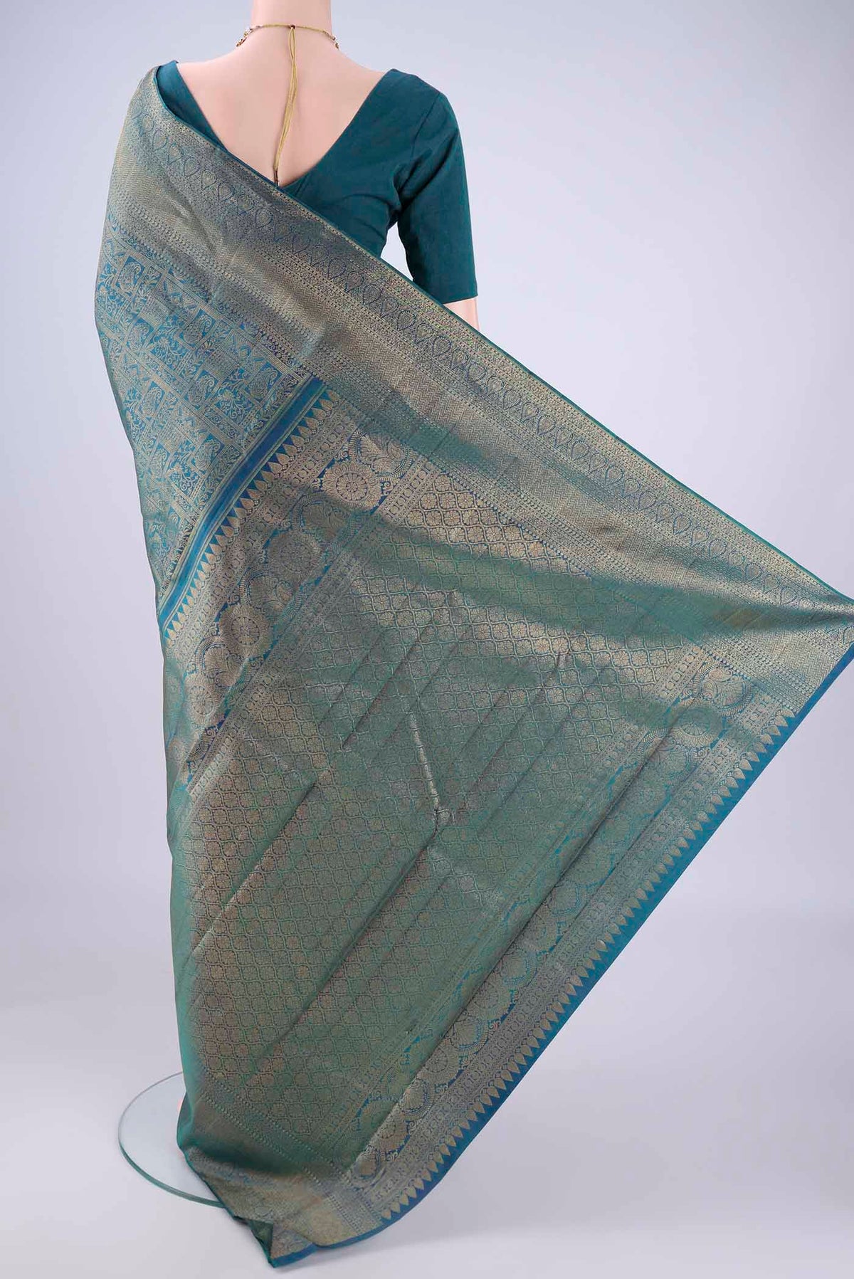 Flat view of Peacock Blue Kanchipuram Silk Saree with Zari Brocade on the body and Zari Border. 