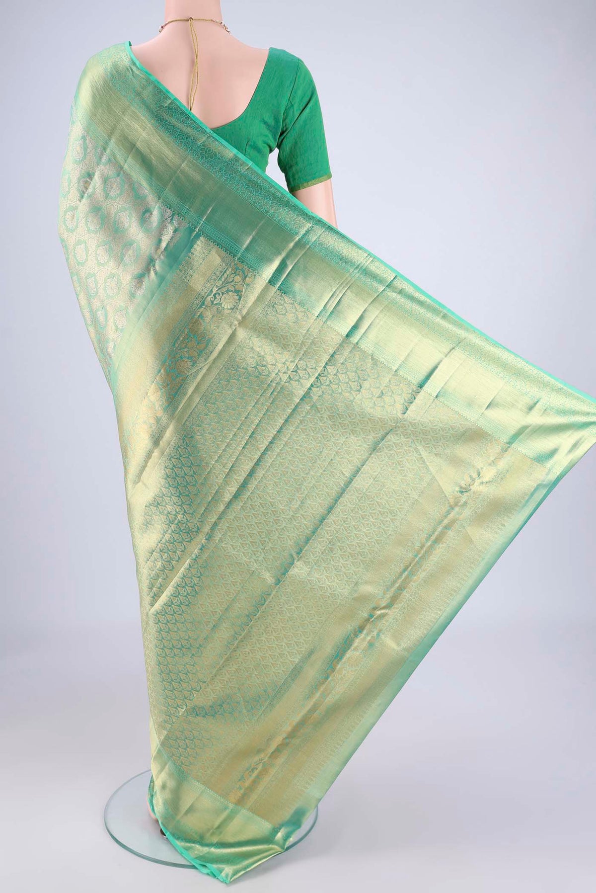 Flat view of Sea Green Kanjivaram Tissue Silk Saree with Zari Brocade on the body and Zari Border. 