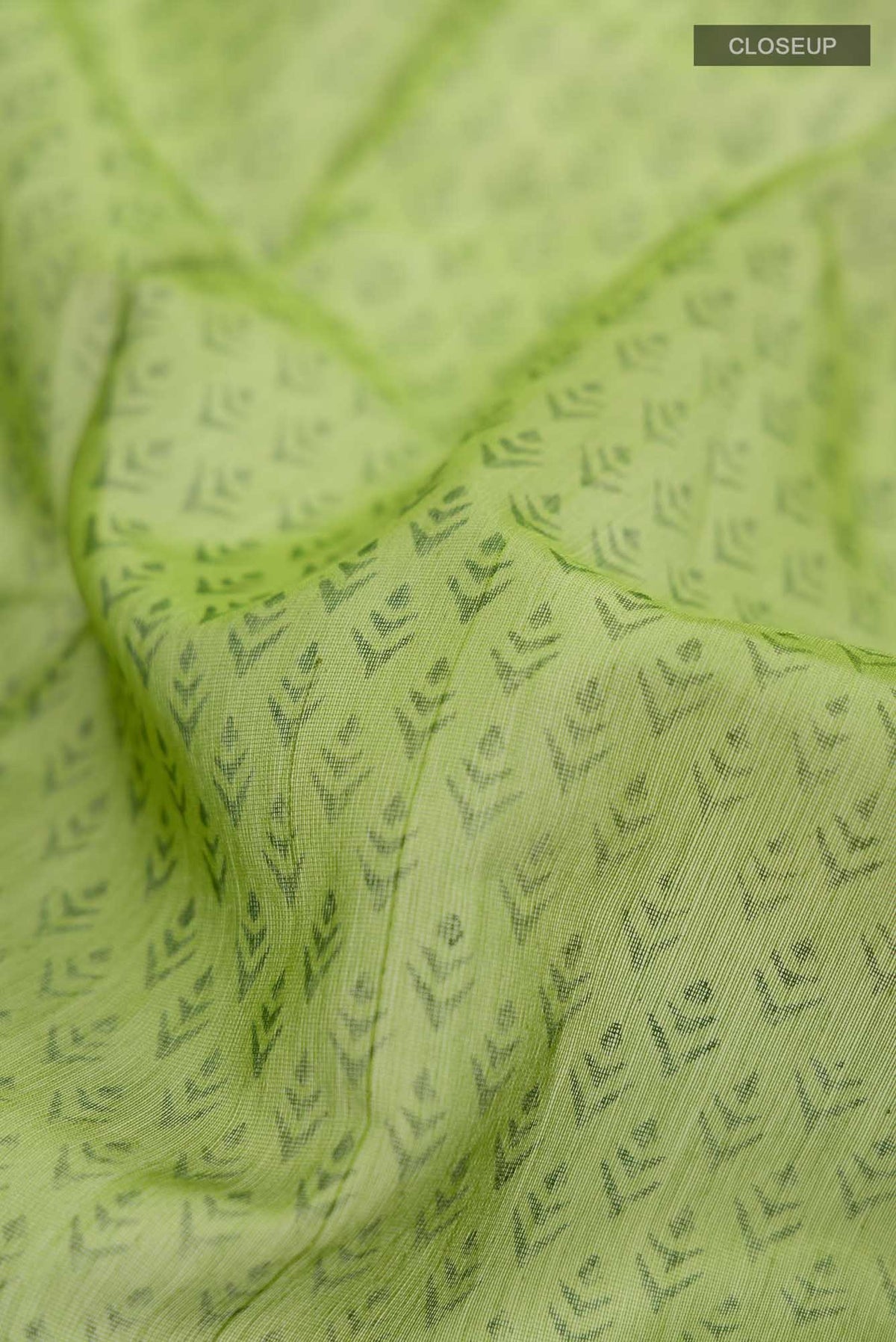 Close up of Green Maheshwari Silk Cotton Saree with Printed design on the body and Zari Border.  displaying folds