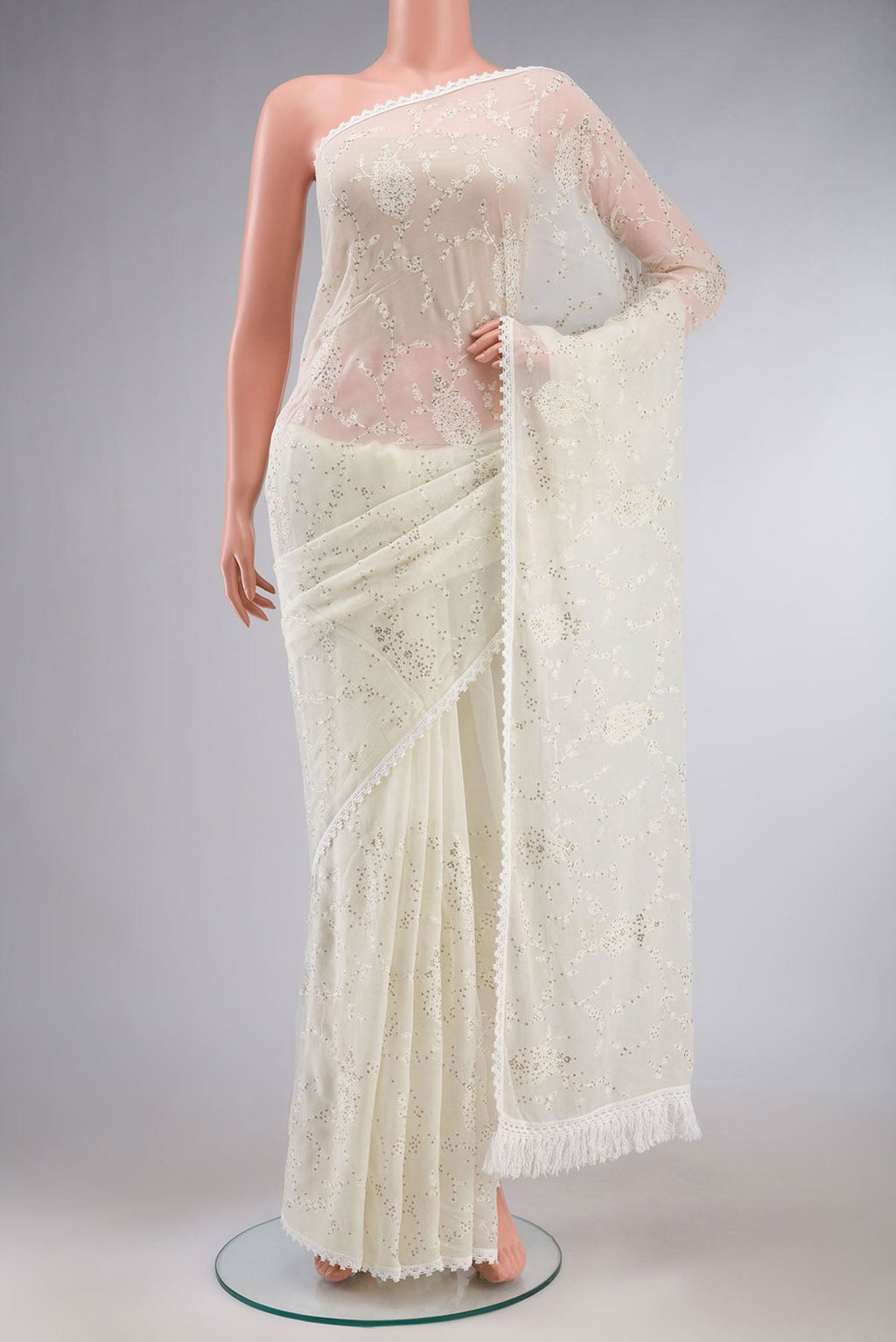Cream Blended Chiffon Saree with Embroidery on the body and Lace Border.  displayed on a mannequin