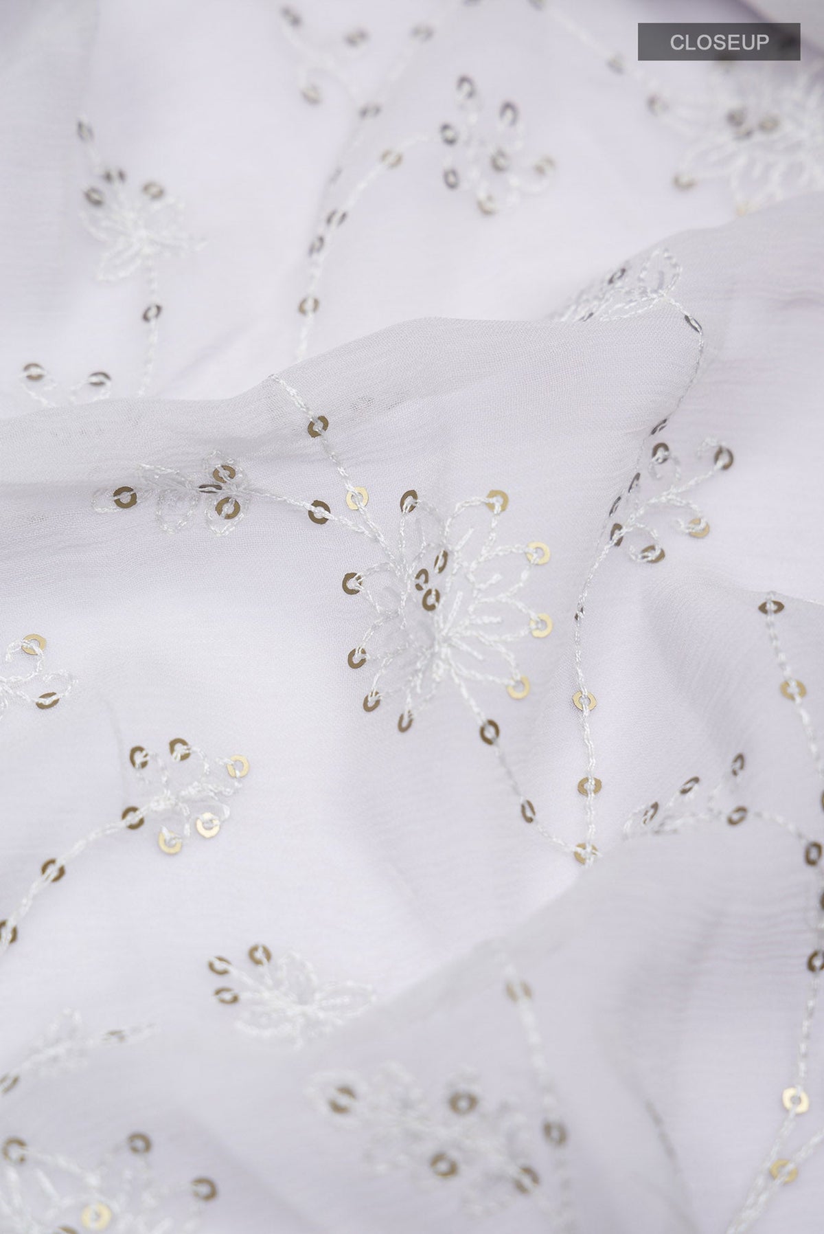 Close up of Grey Blended Chiffon Saree with Embroidery on the body and Lace Border.  displaying folds