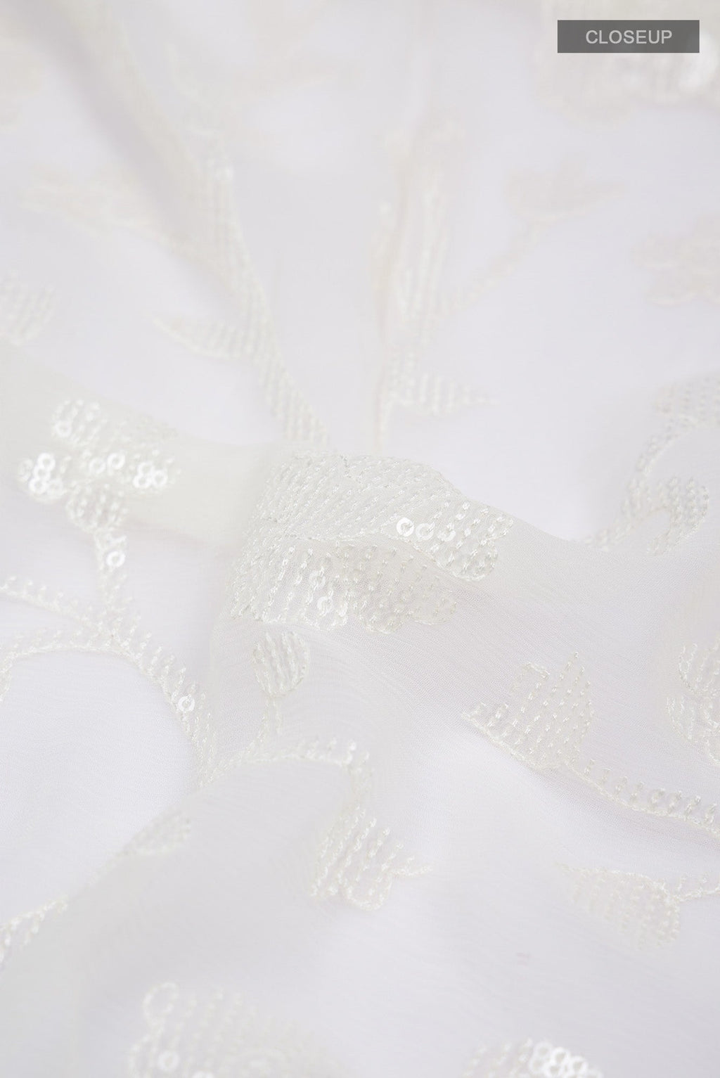 Close up of Cream Blended Chiffon Saree with Embroidery on the body and Lace Border.  displaying folds