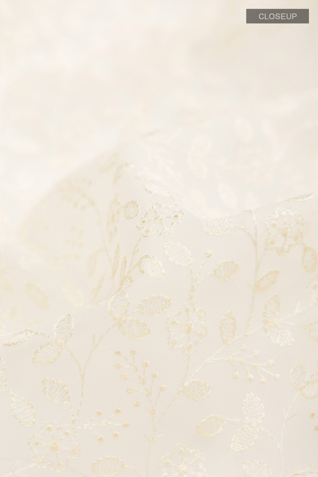 Close up of Cream Blended Kora Cotton Saree with Embroidery on the body and Zari And Thread Border.  displaying folds