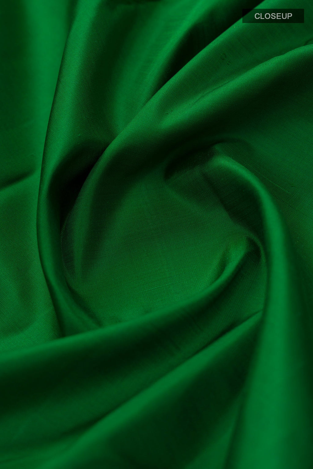 Close up of Green Kanchipuram Silk Saree with Plain Body and Zari Border.  displaying folds