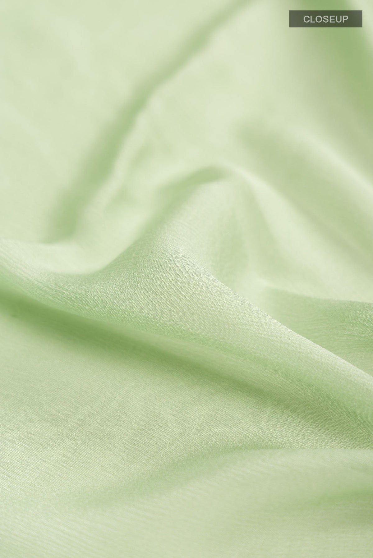 Close up of Green Mysore Chiffon Saree with Plain Body and Zari Border.  displaying folds