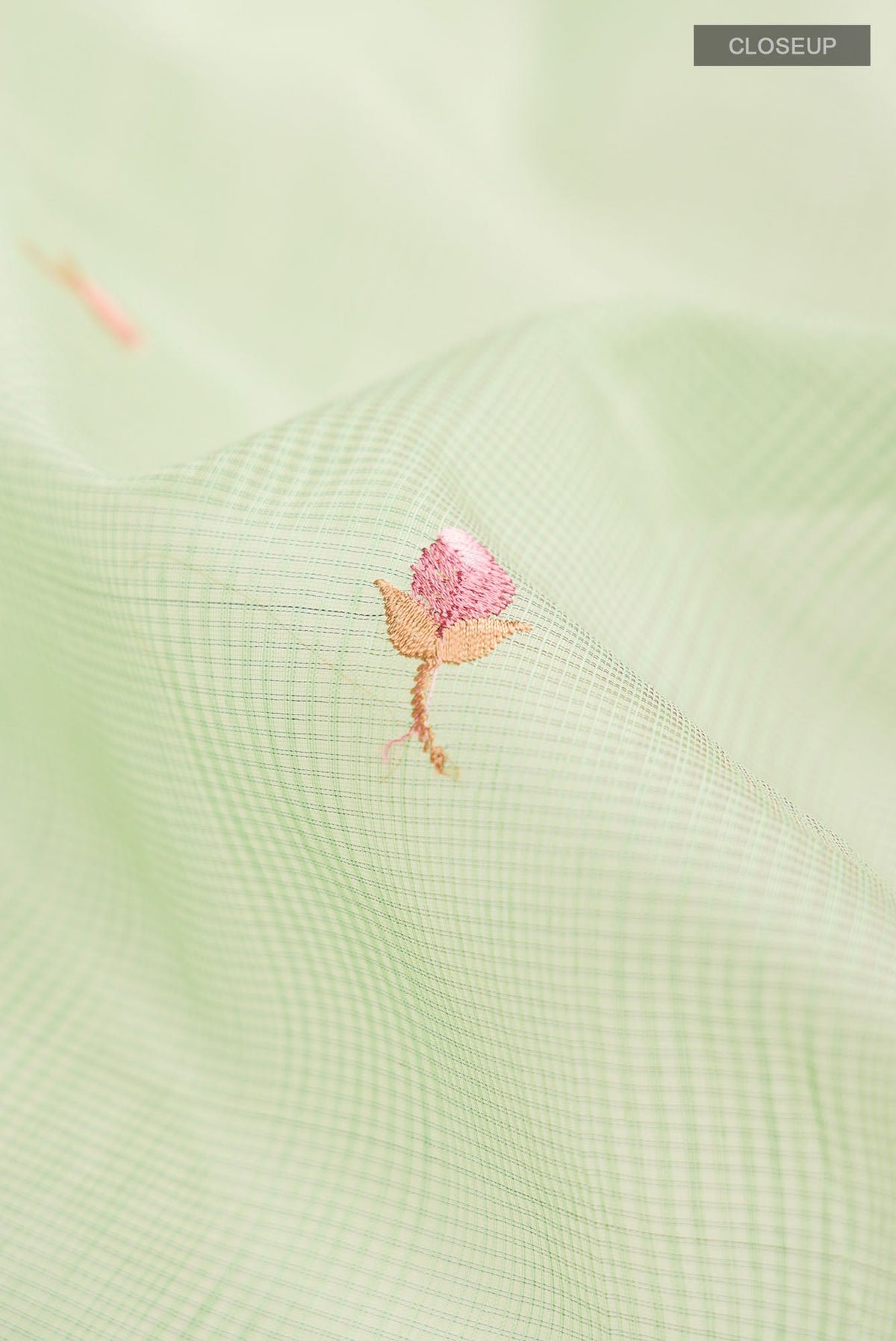 Close up of Green Blended Kota Cotton Saree with Embroidery on the body and Zari Border.  displaying folds