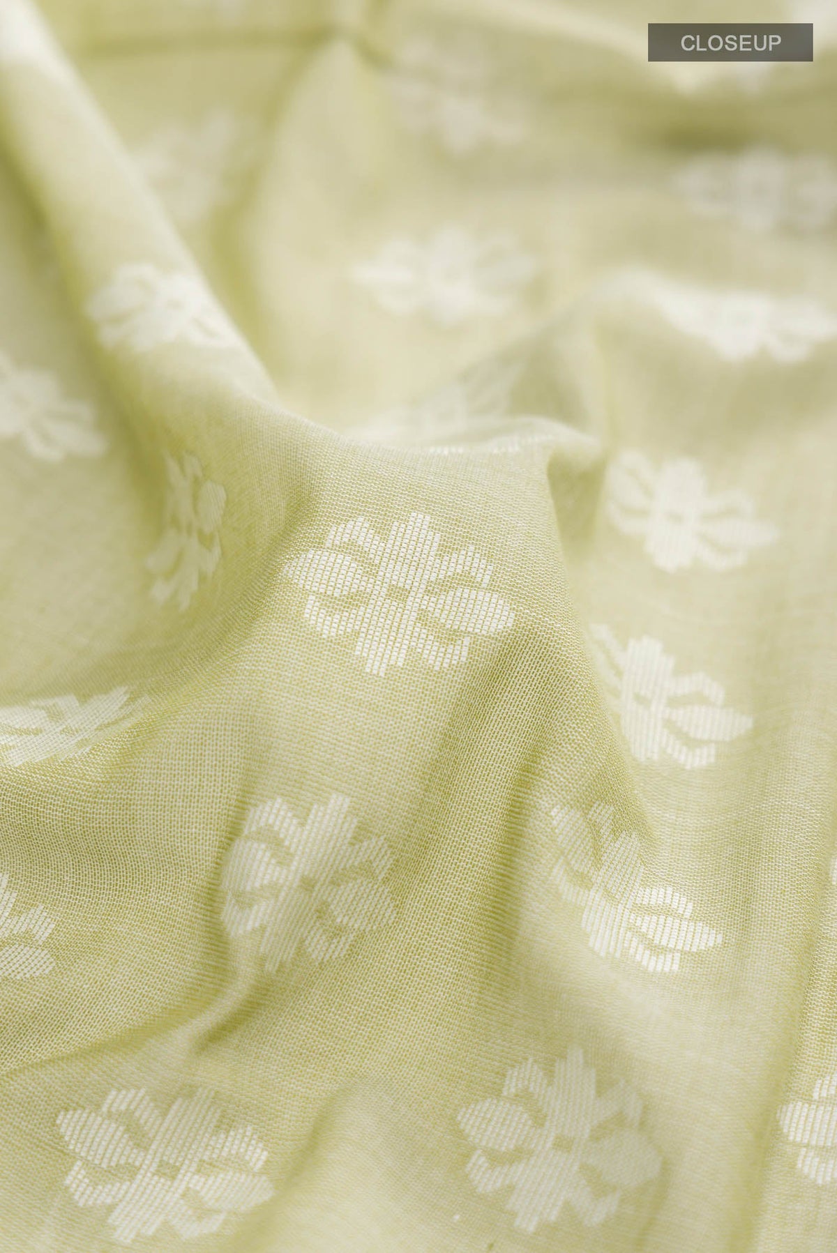 Close up of Light Green Bengal Cotton Saree with Jamdani on the body and Thread Border displaying folds