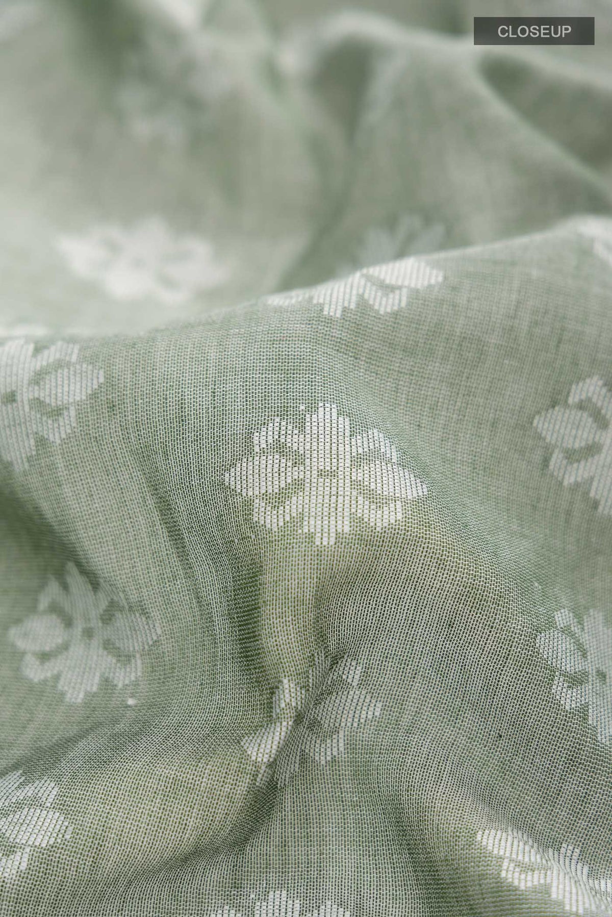 Close up of Olive Green Bengal Cotton Saree with Jamdani on the body and Thread Border displaying folds