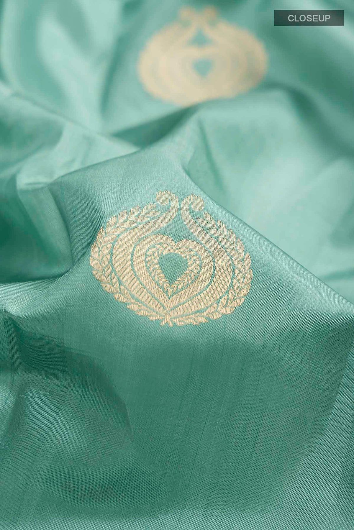 Close up of Green Banarasi Katan Silk Saree with Zari Butta on the body and Zari Border displaying folds