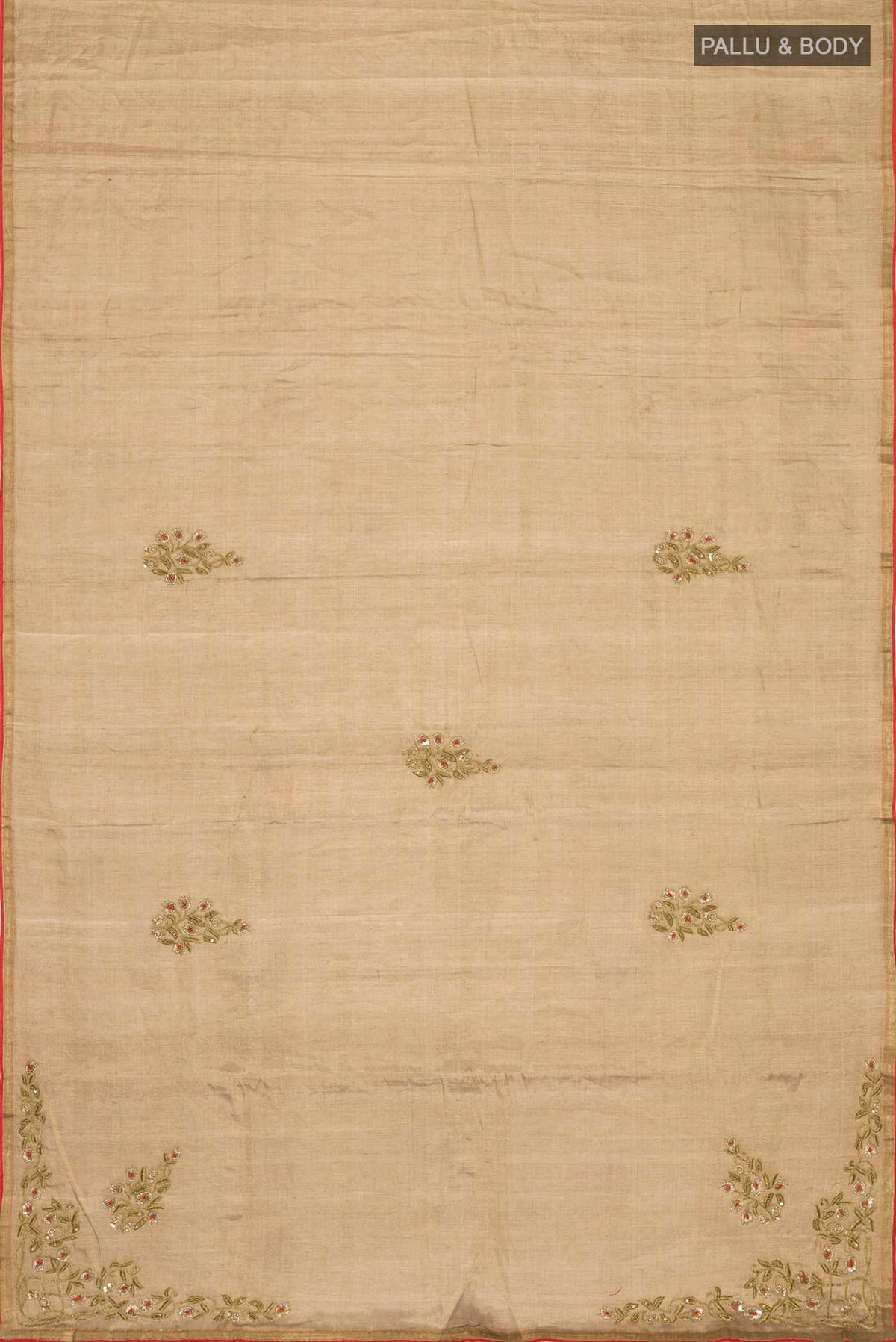 Flat view of Rumana is crafted in delicate tissue enriched with antique-gold zardozi, brought to life through dabka, sequins, and coloured beads The pallu unfolds with konia motifs and flowing pomegranate vines, anchored by a drop-shaped buta rendered in a stylised pomegranate form The body carries evenly placed butas that continue into the pleats, lending the saree a gentle, composed rhythm A classic gota trim completes this elegant expression of symbolic craft