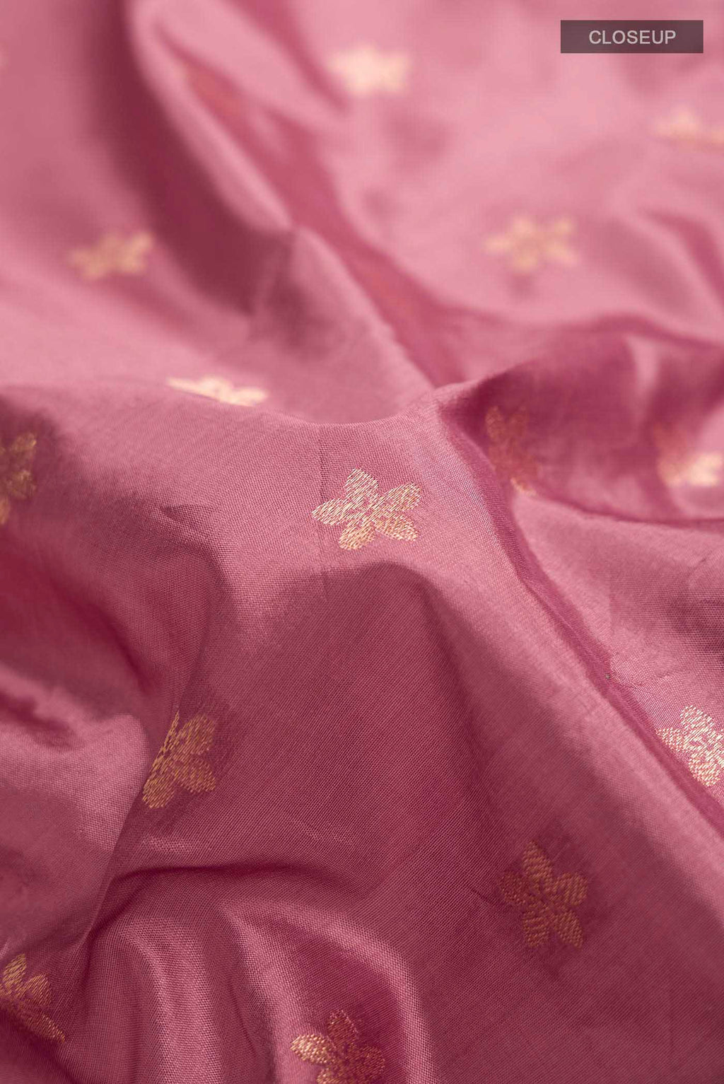 Close up of Coral Banarasi Katan Silk Saree with Zari Butta on the body and Zari Border displaying folds
