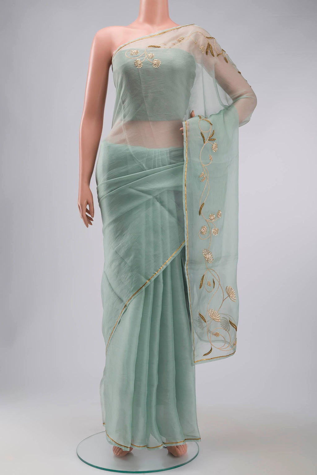 Green Organza Silk Saree with Plain Body and Embroidery Border displayed on a mannequin