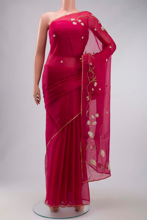 Bahar, crafted in silk organza, features delicate pani-zari enriched with zardozi, gota work, and dabka embroidery Its defining element is an off-center floral vine running vertically through the body, breaking symmetry with quiet intent Inspired by Art Nouveau?s flowing lines, the vine is rendered in slender leaves, zari chain-stitched stems, and alternating gota and zardozi flowers The pallu trails gently onto the body in scattered embroidered blooms displayed on a mannequin