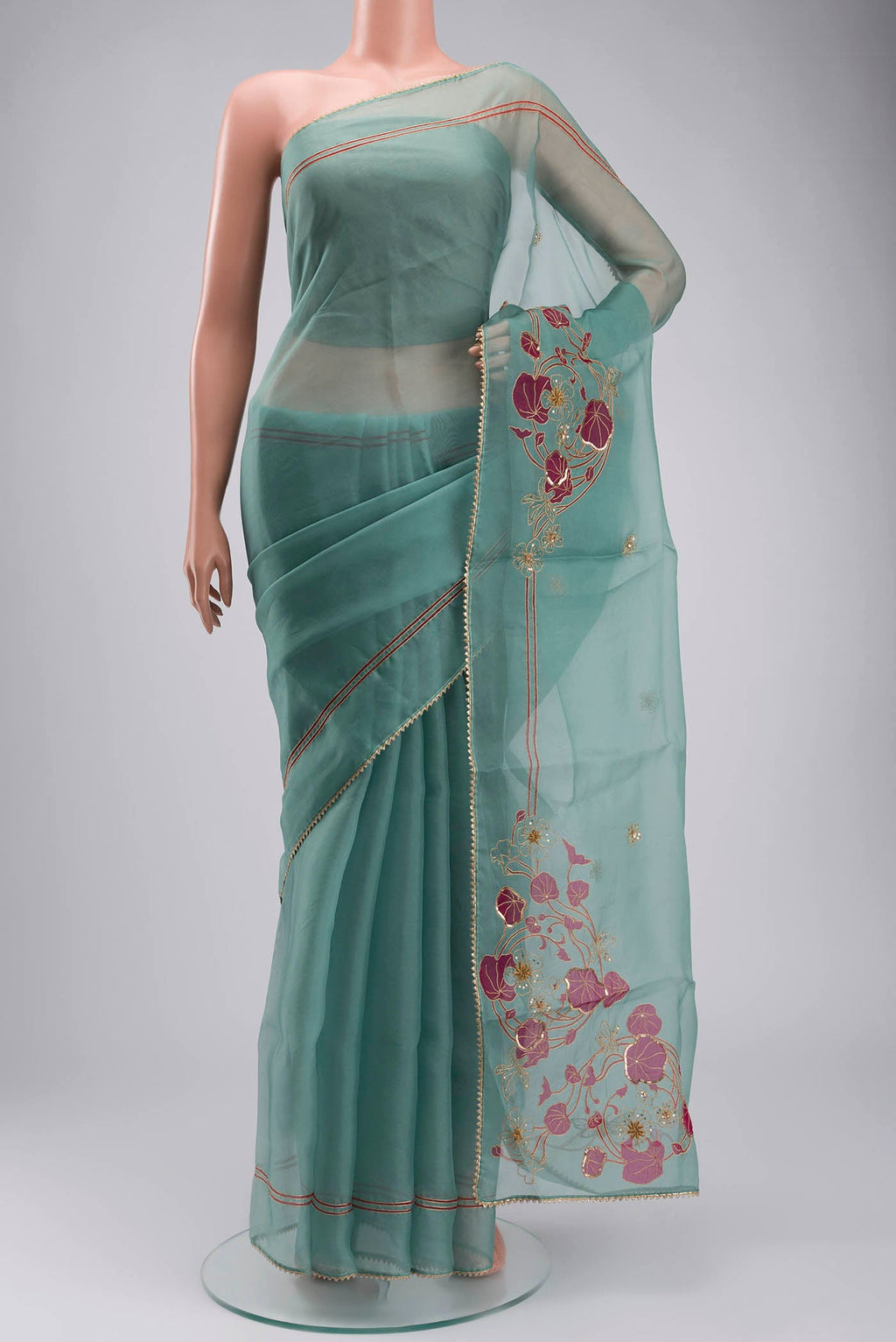 Green Organza Silk Saree with Plain Body and Embroidery Border displayed on a mannequin