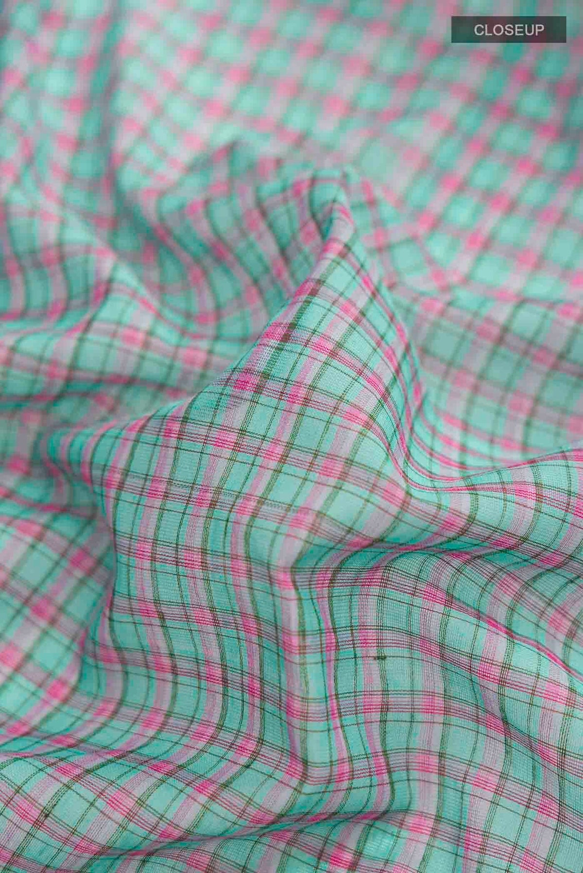 Close up of Patang features fine multi-coloured checks woven using four harmonious hues, creating a lively yet balanced design Translating to ?te)n Hindi, the saree reflects the light, easy spirit of a patang gliding across an open sky The border and pallu are minimal, finished with delicate zari accents that add subtle richness With its balanced play of colour, it makes for a breathable, comfortable drape displaying folds