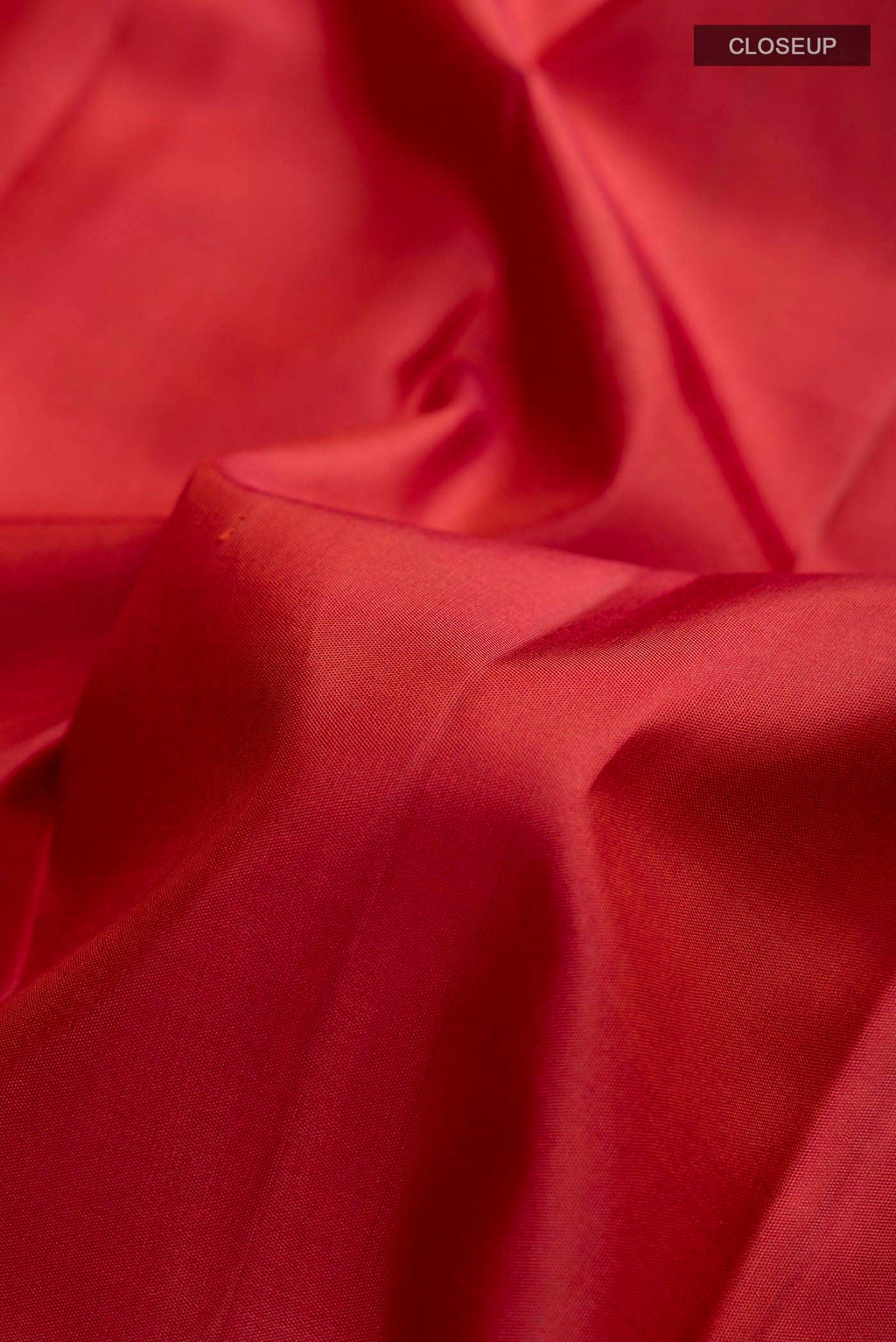 Close up of Maroon Kanchipuram Silk Saree with Zari Butta on the body and Zari Border displaying folds