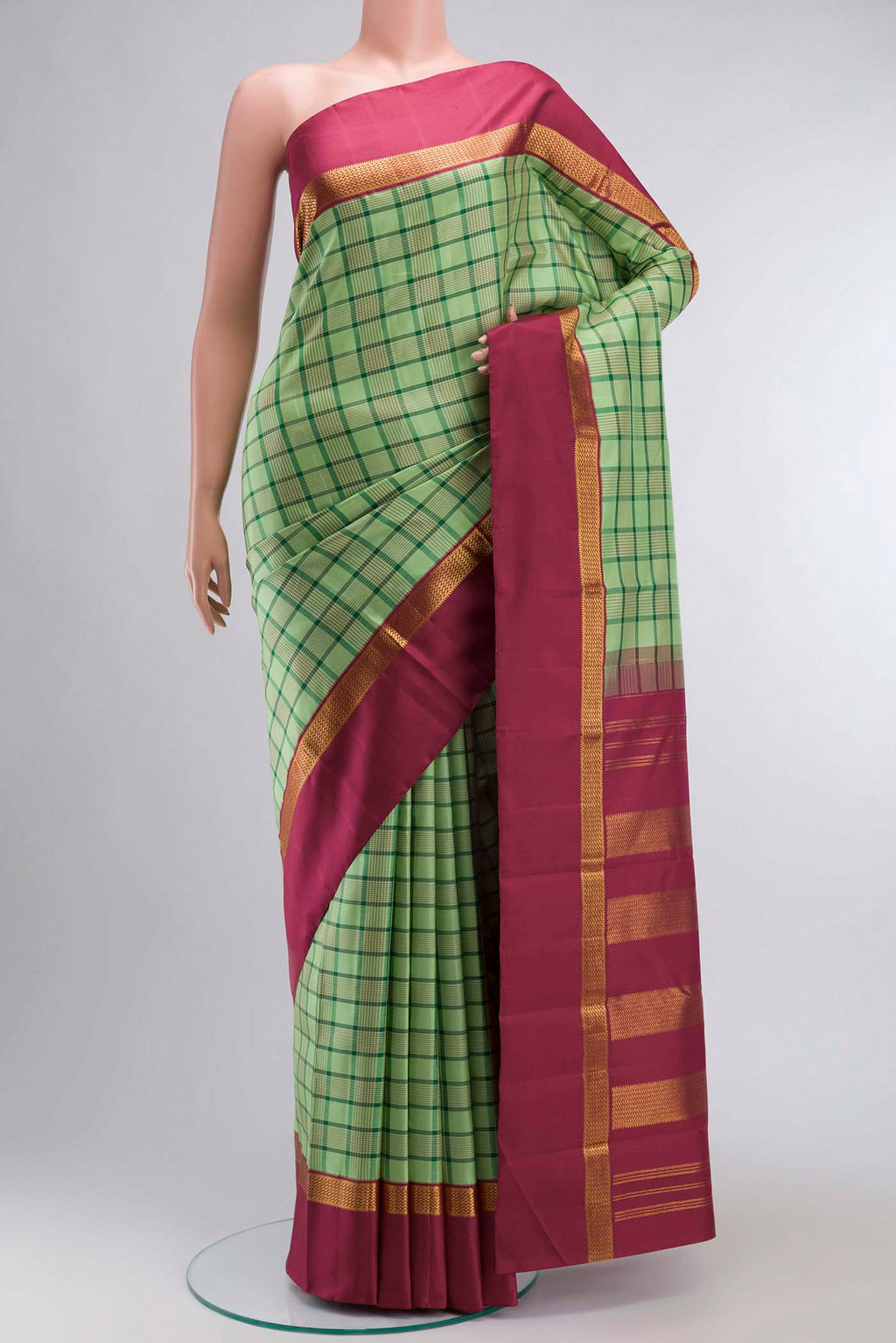 Green Kanchipuram Silk Saree with Checked design on the body and Zari Border displayed on a mannequin