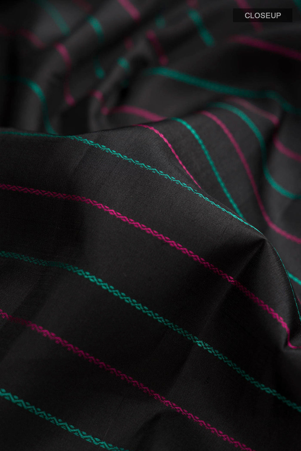 Close up of Black Kanchipuram Silk Saree with Stripes on the body and Zari Border displaying folds