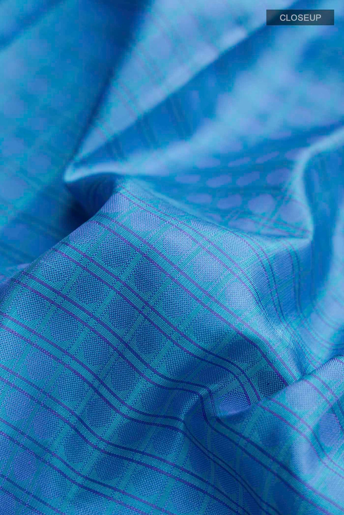 Close up of Blue Kanchipuram Silk Saree with Thread Butta on the body and Zari Border displaying folds