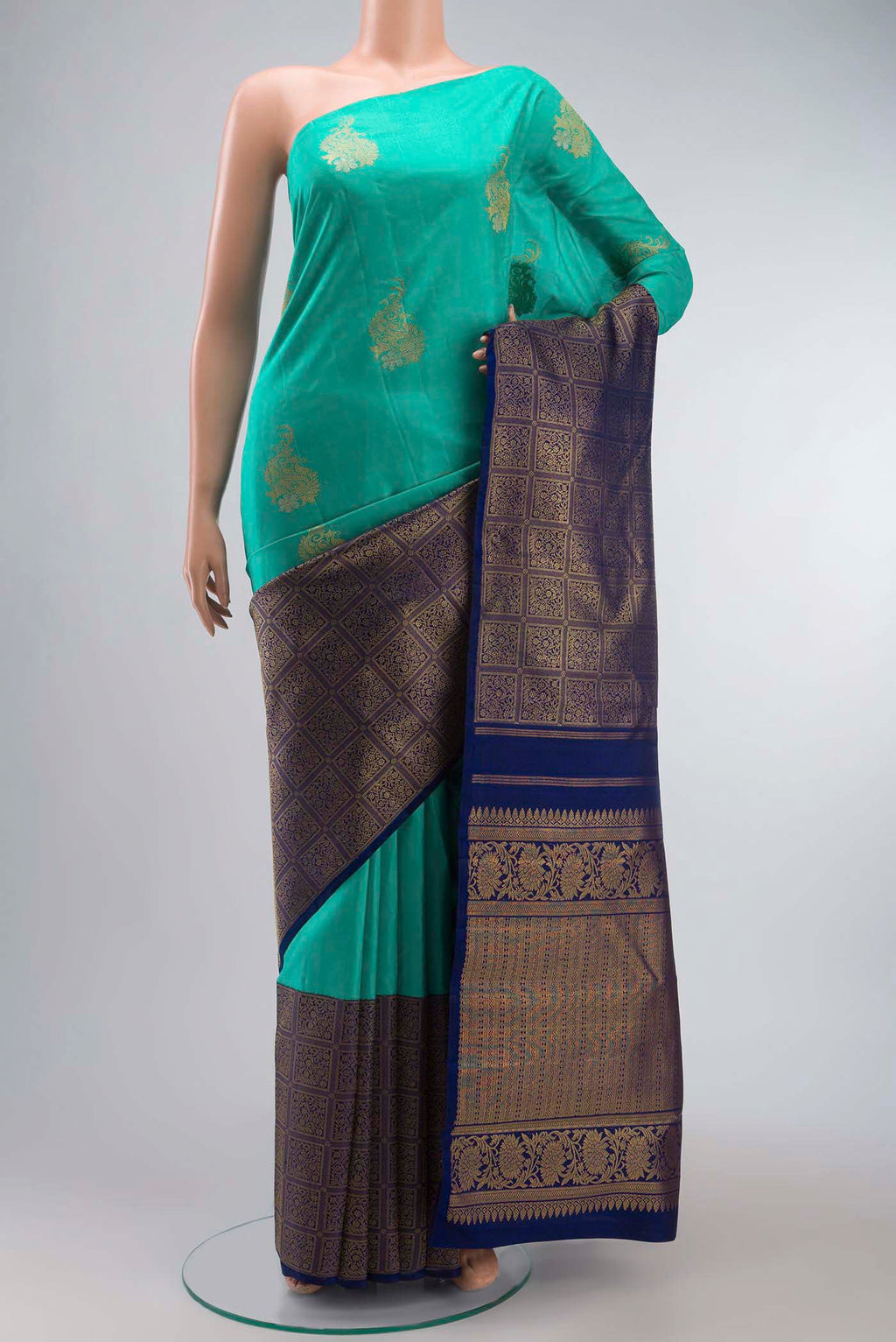 Green Kanchipuram Silk Saree with Zari Butta on the body and Zari Border displayed on a mannequin