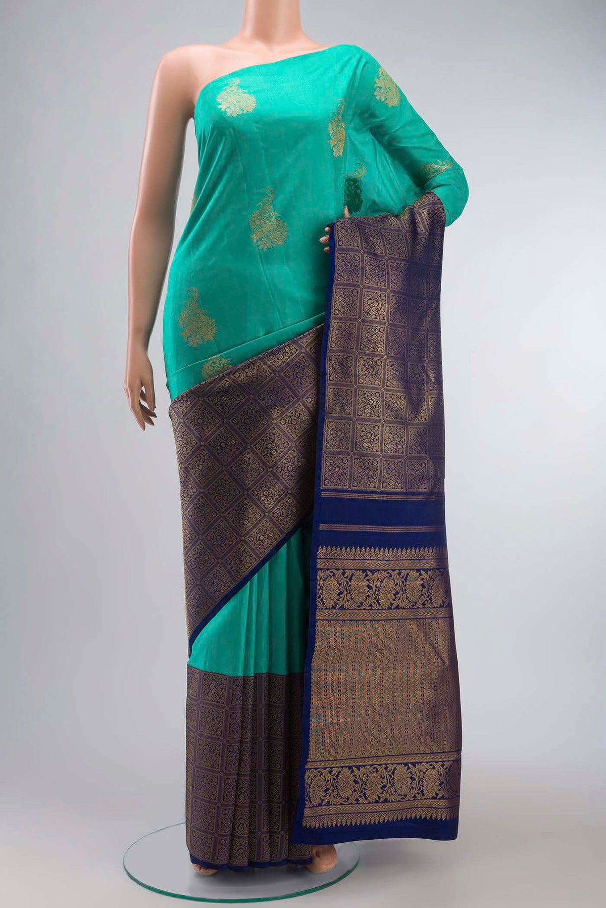 Green Kanchipuram Silk Saree with Zari Butta on the body and Zari Border displayed on a mannequin