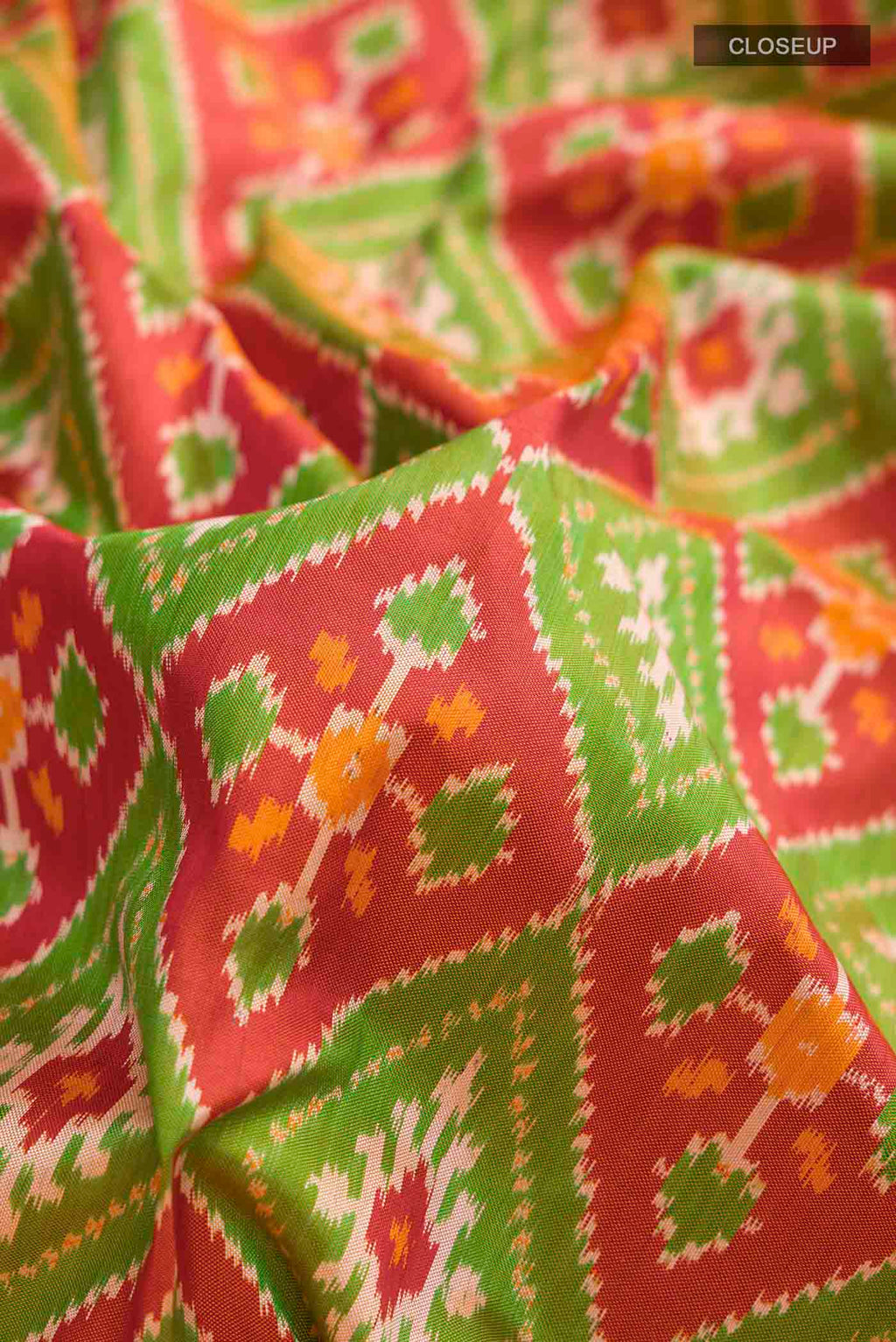 Close up of Rust Pochampally Silk Saree with Pure Ikat on the body and Zari Border displaying folds