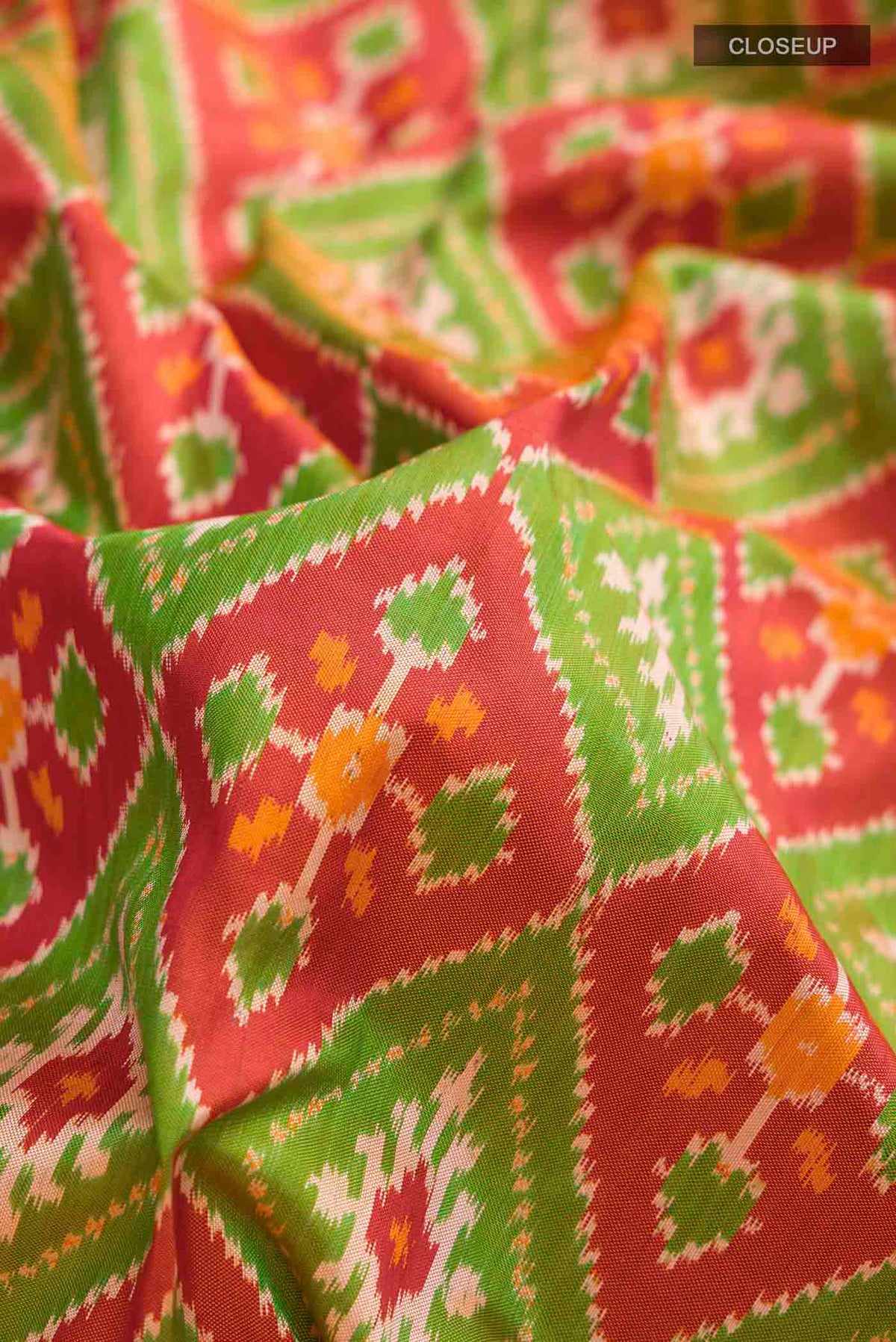 Close up of Rust Pochampally Silk Saree with Pure Ikat on the body and Zari Border displaying folds