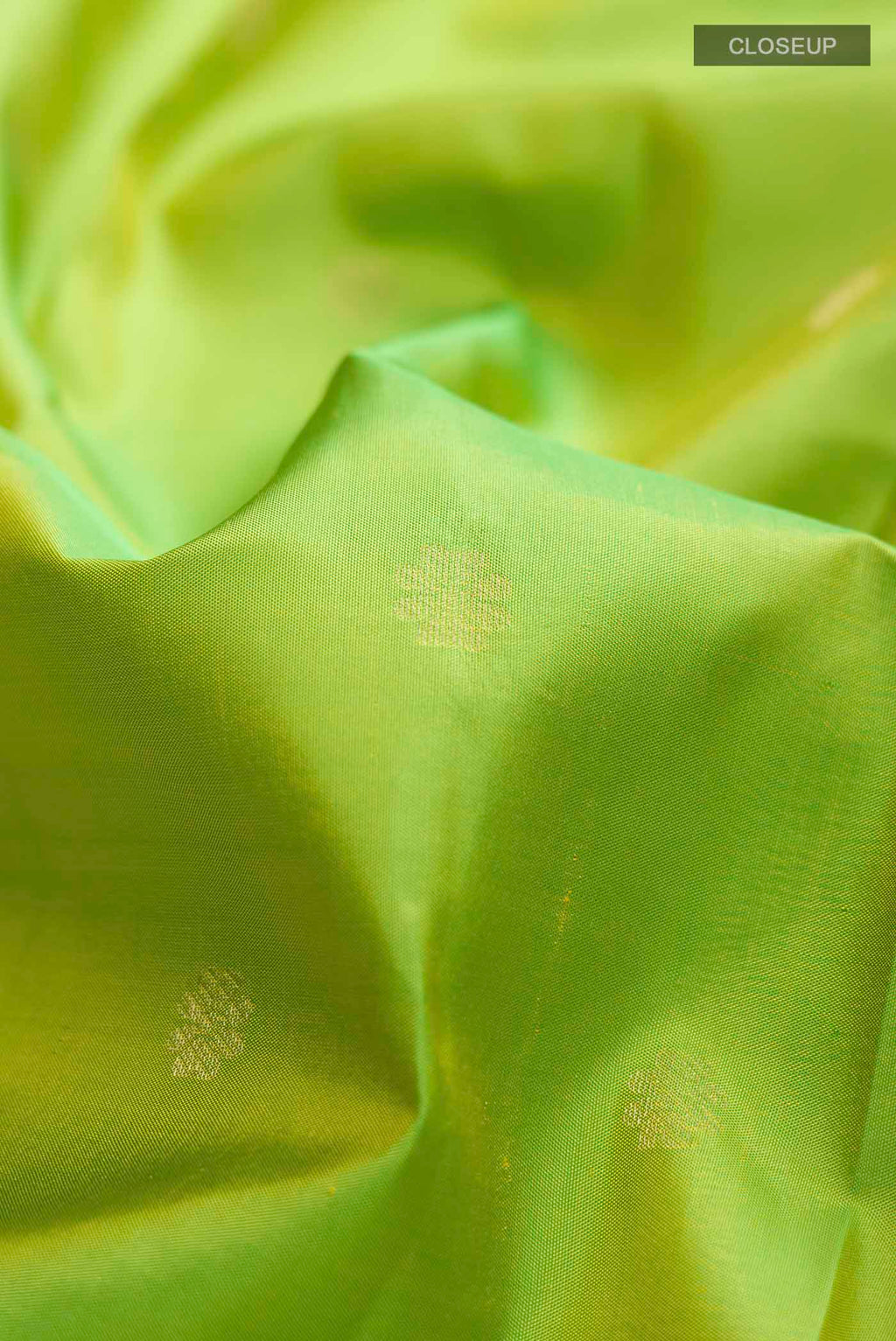 Close up of Green Kanchipuram Silk Saree with Zari Butta on the body and Zari Border displaying folds