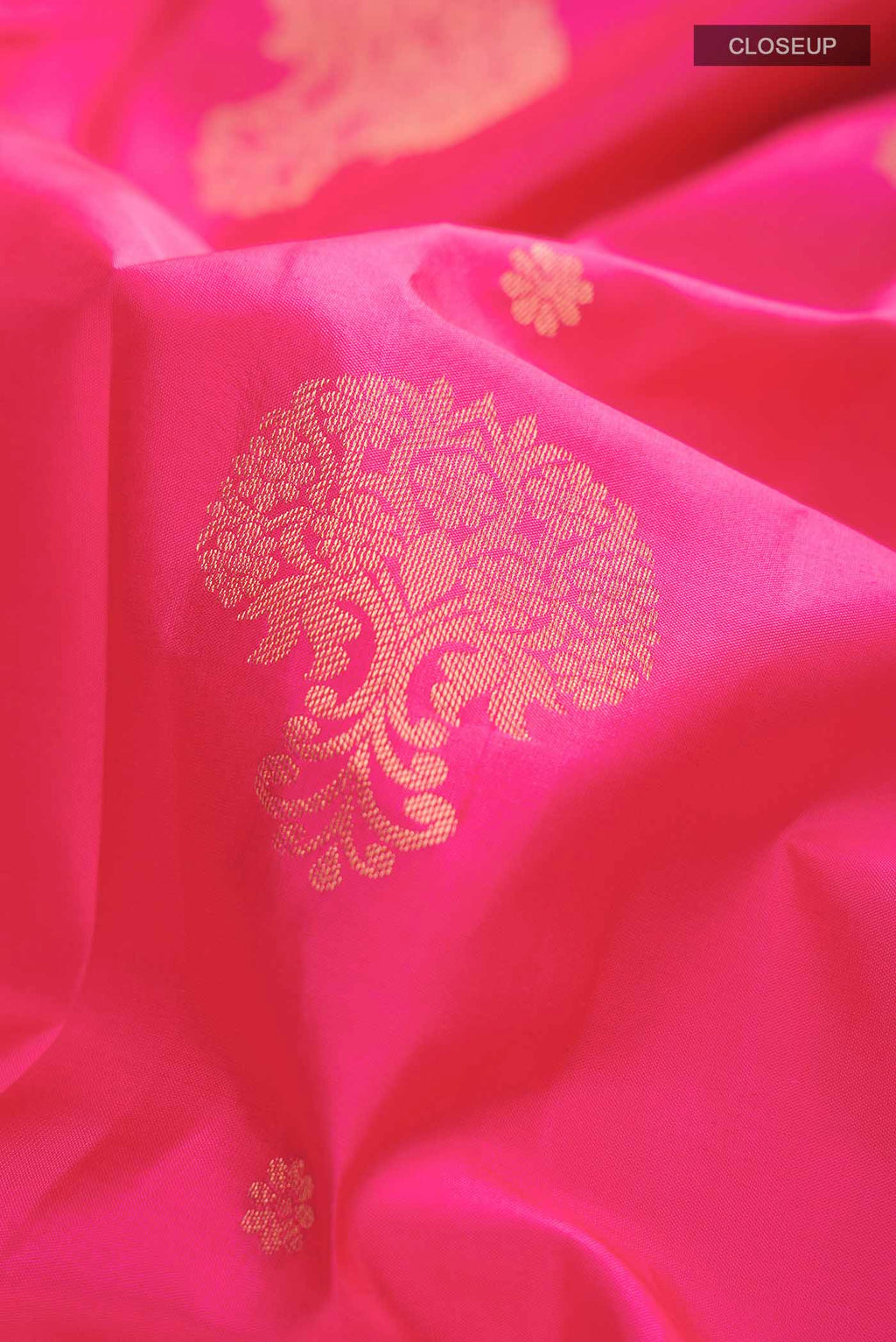 Close up of Pink Kanchipuram Silk Saree with Zari Butta on the body and Zari Border displaying folds