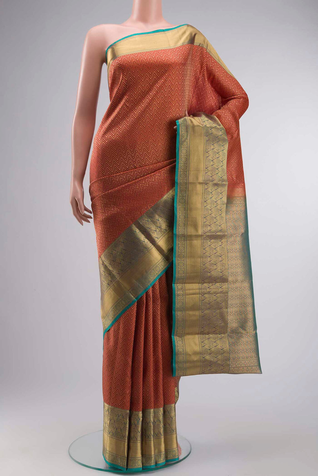 Rust Kanchipuram Silk Saree with Zari Brocade on the body and Zari Border displayed on a mannequin