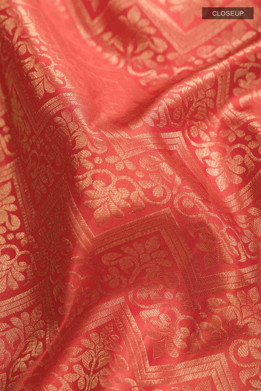 Close up of Orange Kanchipuram Silk Saree with Zari Brocade on the body and Zari Border displaying folds