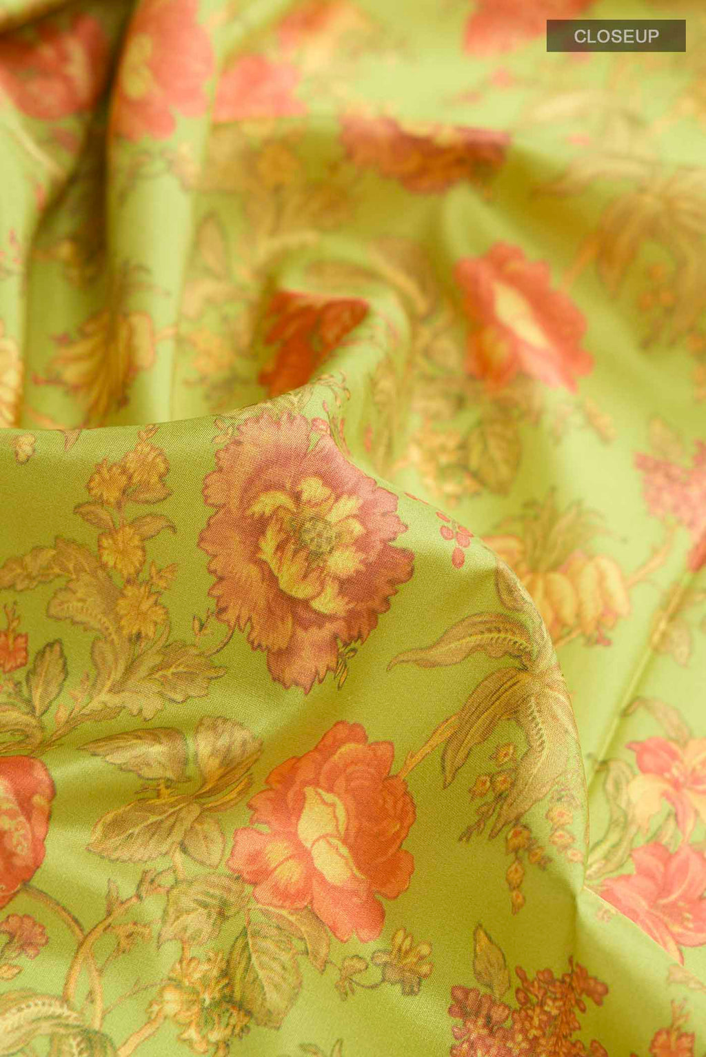 Close up of Green Printed Silk Saree with Floral Print on the body and Zari Border displaying folds