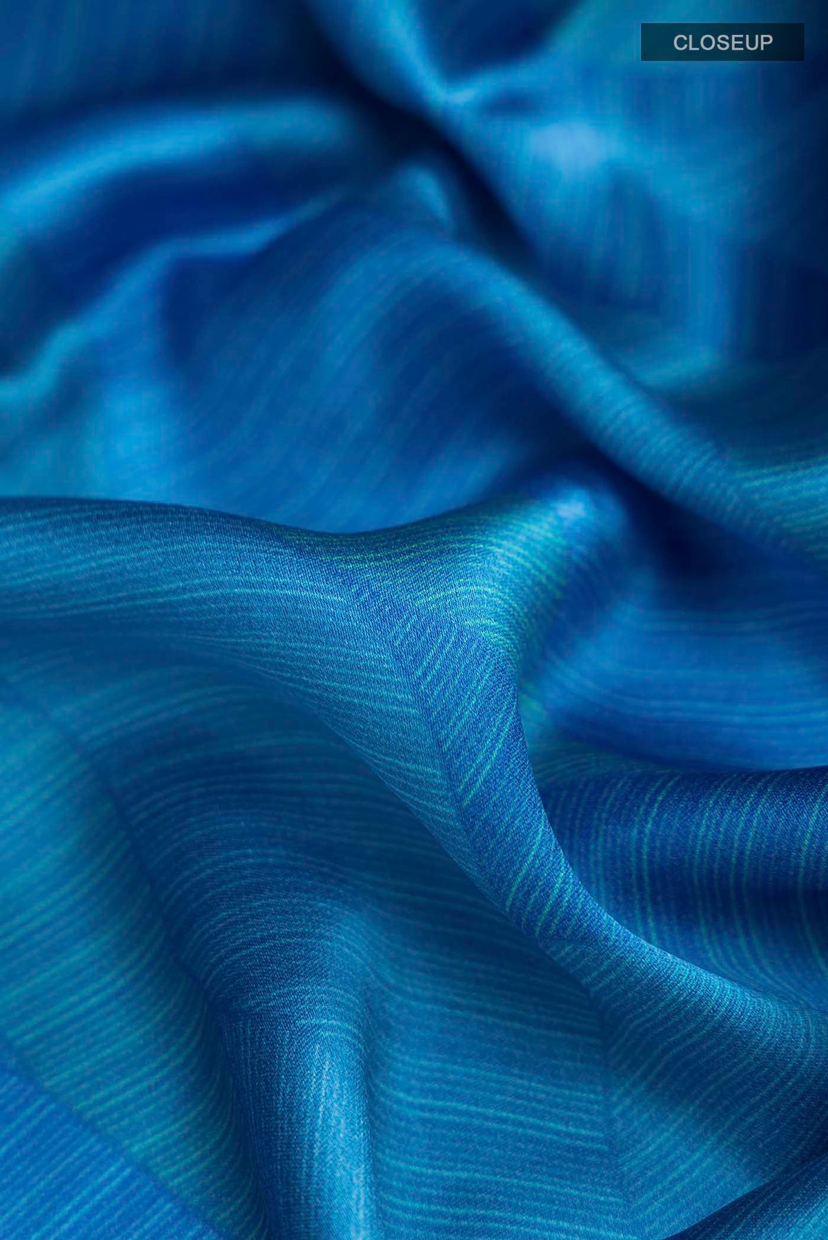 Close up of Blue Mysore Crepe Saree with Printed design on the body and Zari Border displaying folds