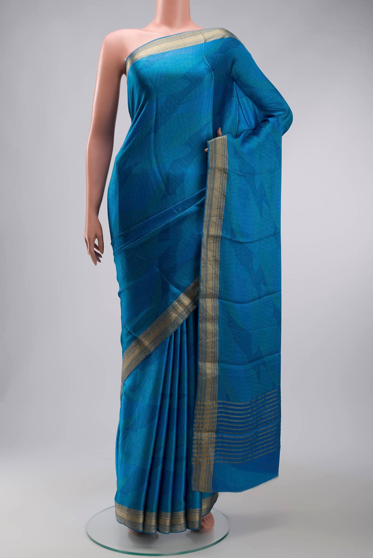 Blue Mysore Crepe Saree with Printed design on the body and Zari Border displayed on a mannequin