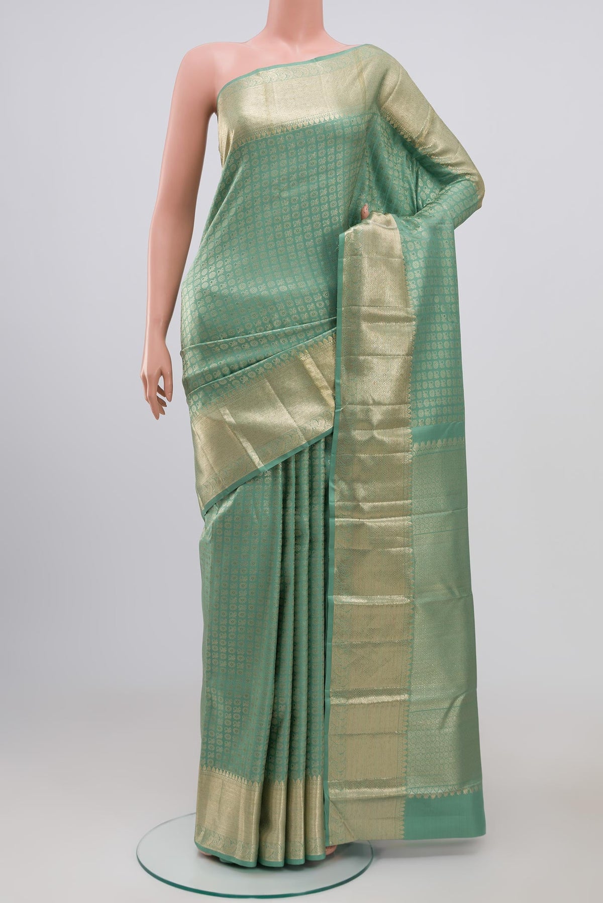 Light Green Kanchipuram Silk Saree with Zari Brocade on the body and Zari Border.  displayed on a mannequin