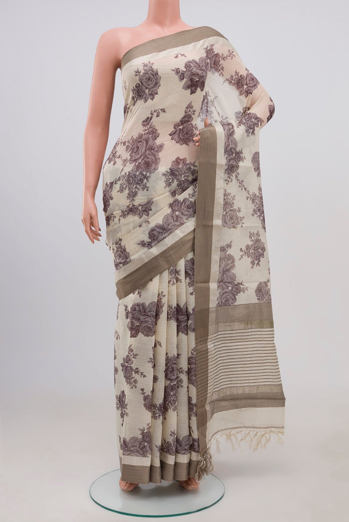 Beige Tussar Saree with Floral Print on the body and Zari Border.  displayed on a mannequin
