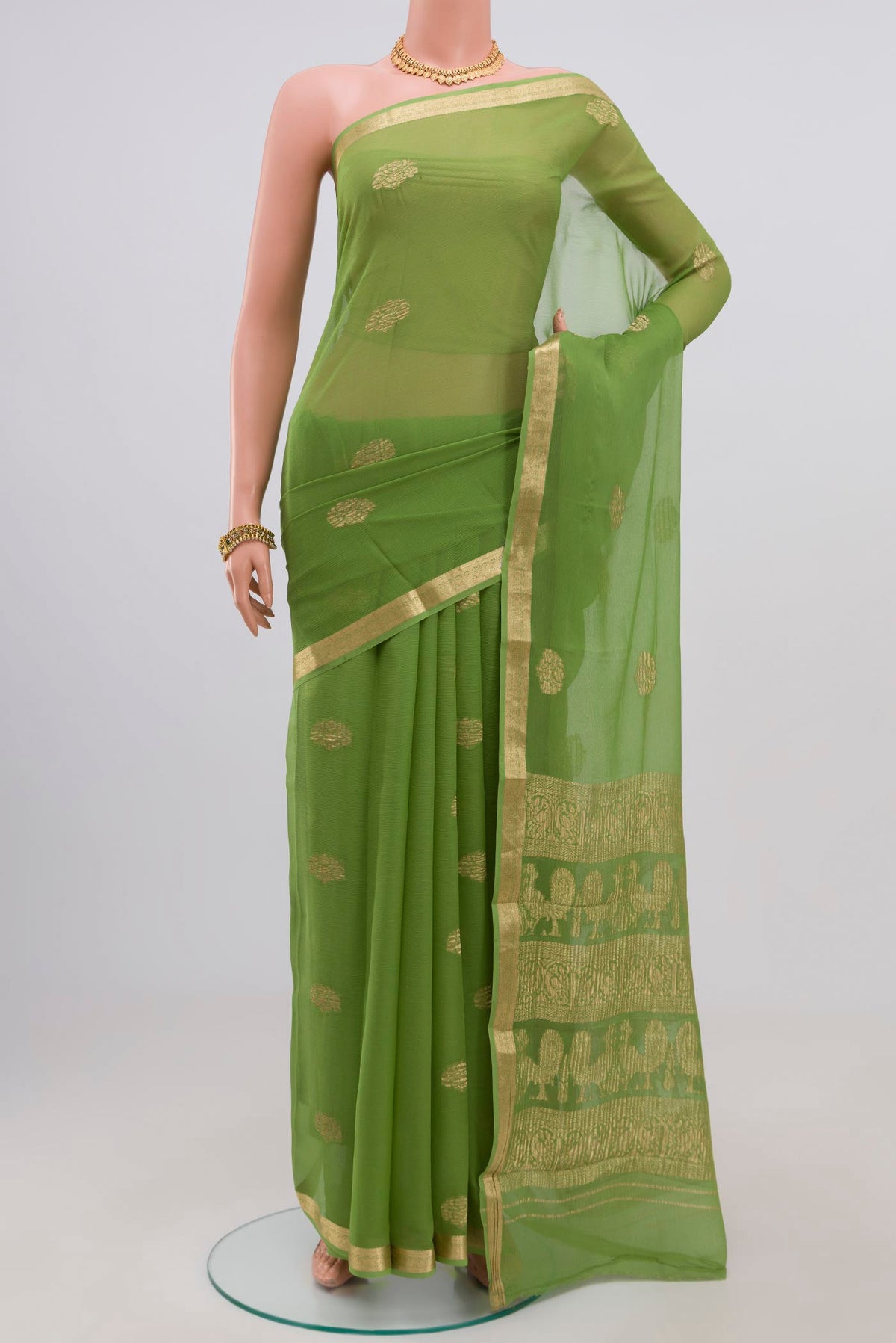 Green Chiffon Saree with Zari Butta on the body and Zari Border.  displayed on a mannequin