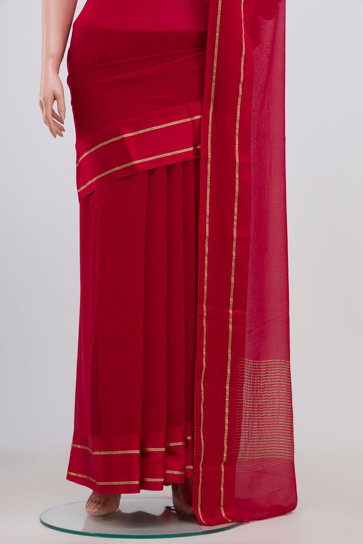 Pleats and pallu of Red Chiffon Saree with Plain Body and Thin Zari Line. 