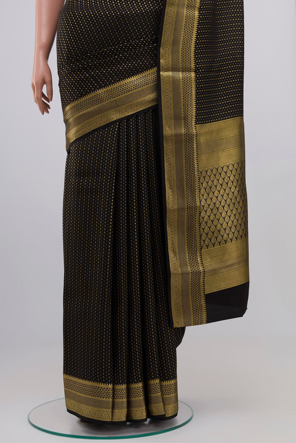 Pleats and pallu of Black Crepe Saree with Zari Butta on the body and Zari Border. 