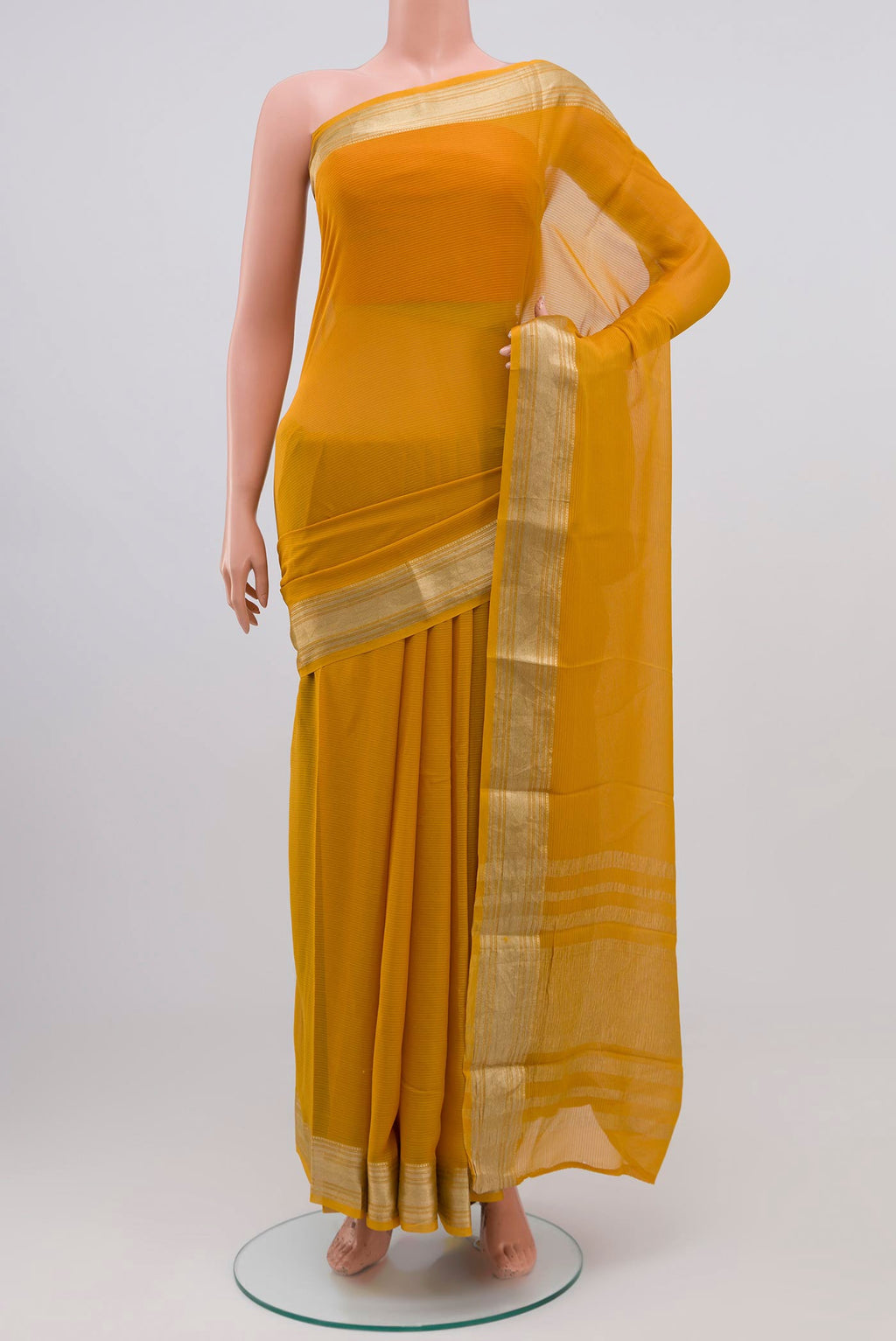 Mustard Georgette Saree with Zari Butta on the body and Zari Border.  displayed on a mannequin