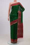 Green Soft Silk Saree with Zari Butta on the body and Fancy Border.  displayed on a mannequin