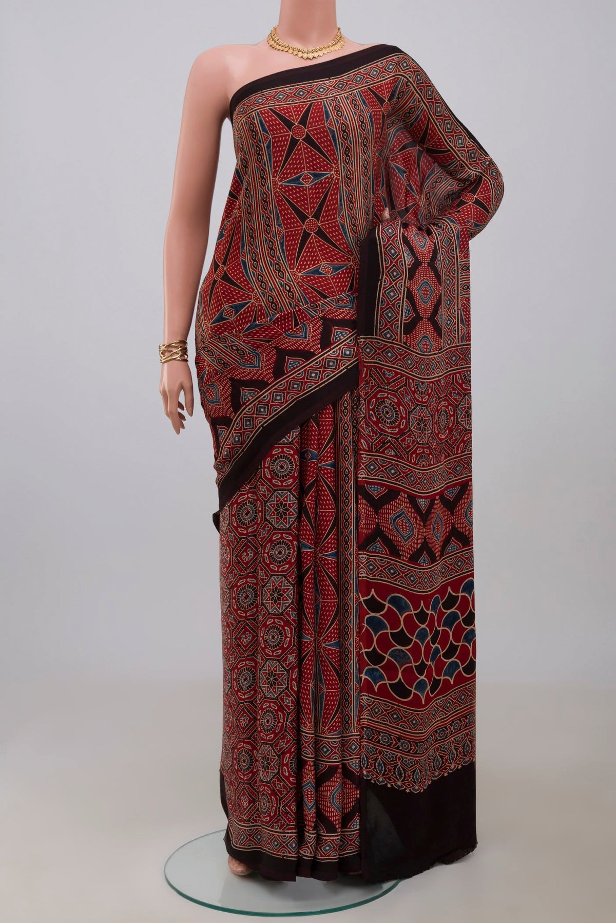Maroon Blended Satin Silk Saree with Ajrakh Print on the body and Printed Border.  displayed on a mannequin