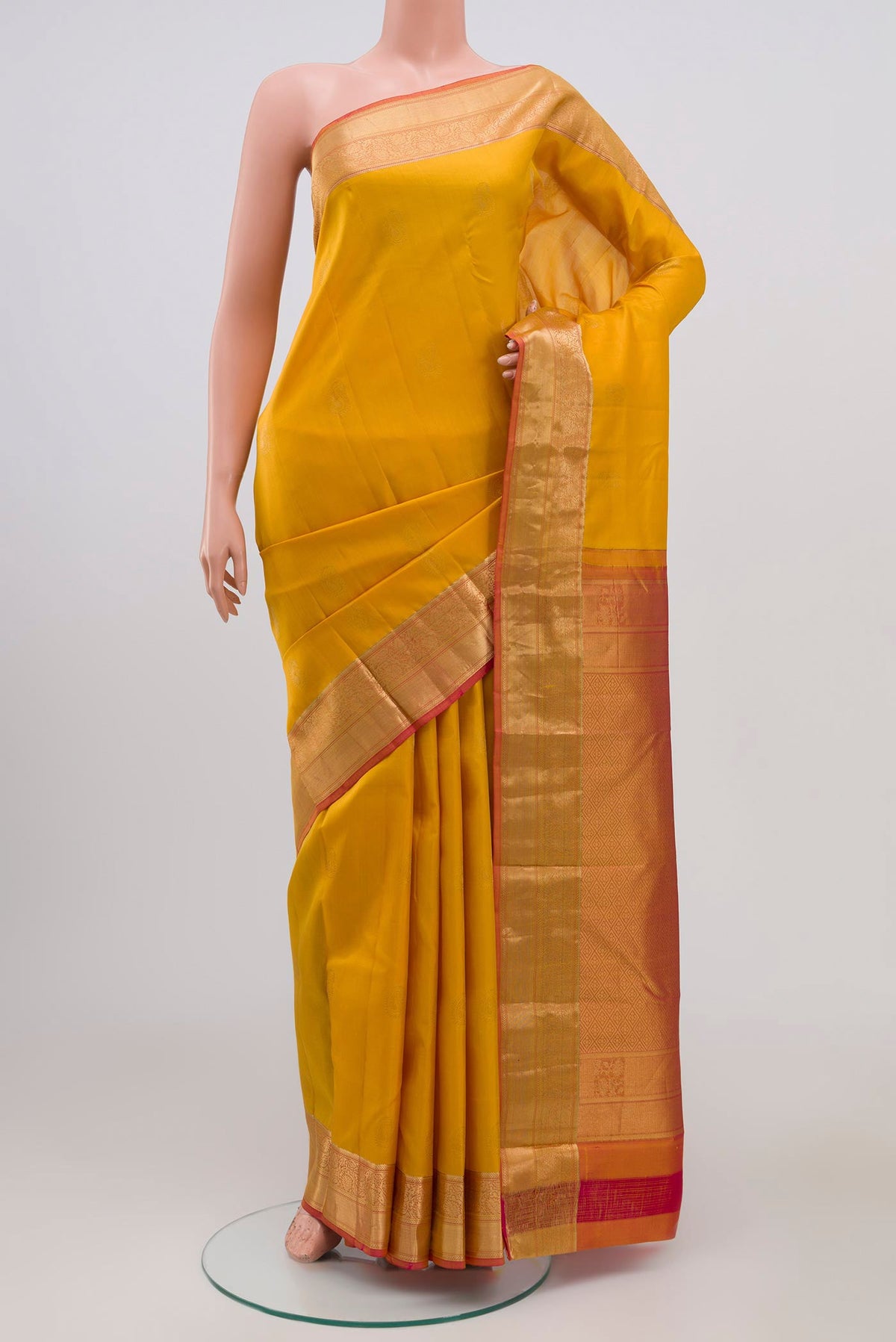 Yellow Kanchipuram Silk Saree with Zari Butta on the body and Zari Border.  displayed on a mannequin