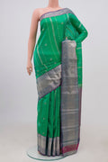 Green Kanchipuram Silk Saree with Zari Butta on the body and Zari Border.  displayed on a mannequin