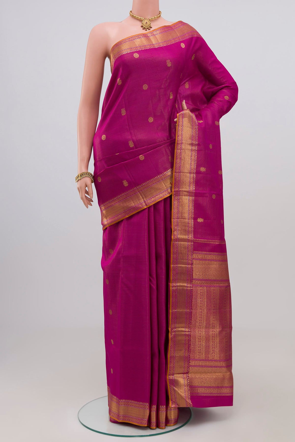 Magenta Kanjivaram Silk Saree with Zari Butta on the body and Zari Border.  displayed on a mannequin