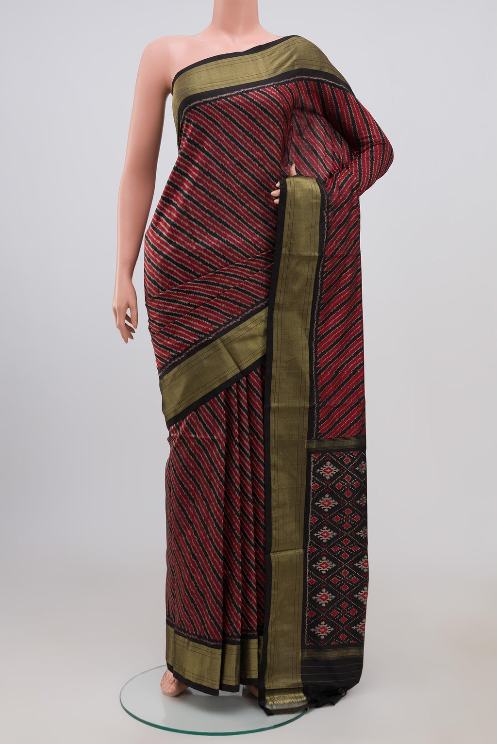 Maroon Pochampally Silk Saree with Ikat design on the body and Zari Border.  displayed on a mannequin